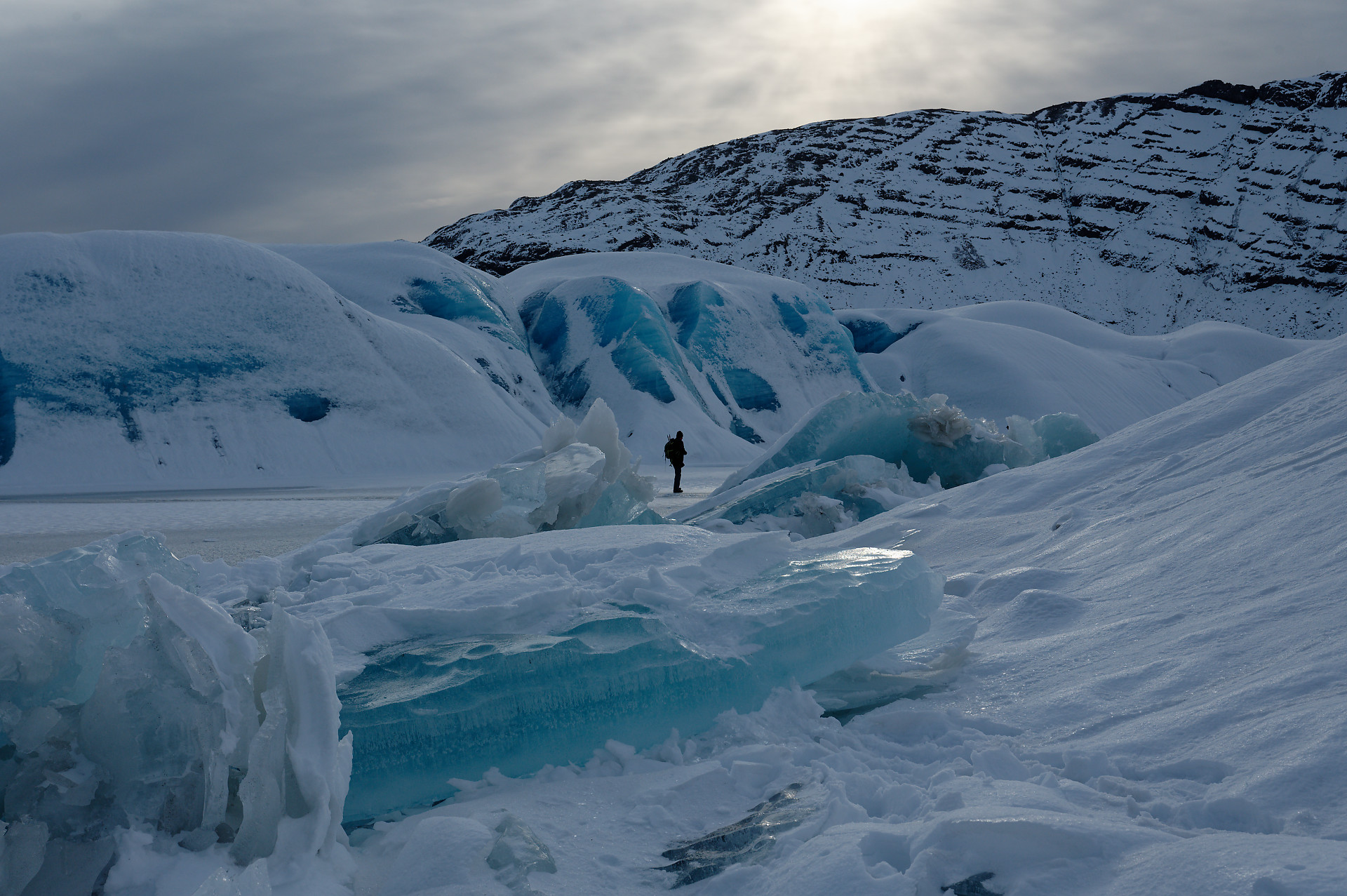 Iceberg et plaque de glace chevauchante sur le lac gelé de Heinabergslon